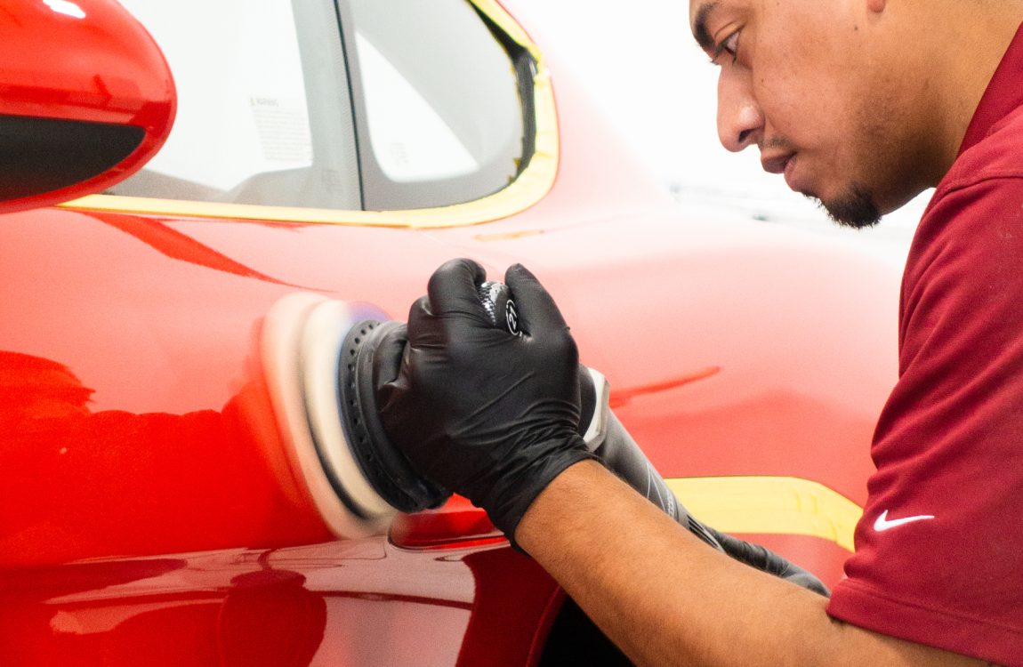technician buffing bright red car